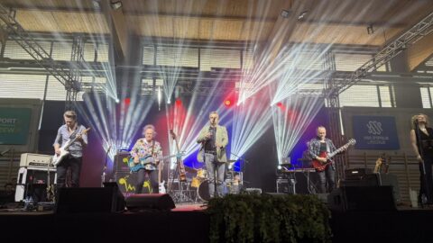 Występy artystów na scenie w hali sportowej.