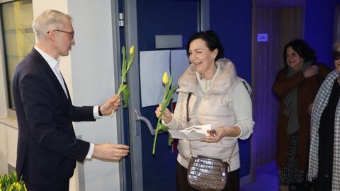 Burmistrz wręczający kwiaty paniom przed koncertem.