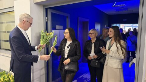 Burmistrz wręczający kwiaty paniom przed koncertem.