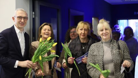 Burmistrz wręczający kwiaty paniom przed koncertem.