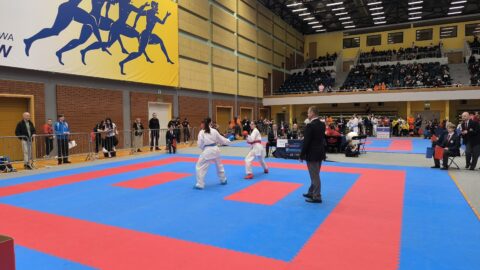 Zawody karate na macie w hali sportowej
