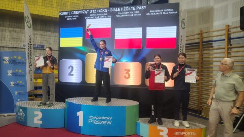 Zawodnicy na podium turnieju karate w hali sportowej w Pleszewie.