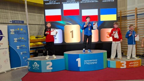 Zawodnicy na podium turnieju karate w hali sportowej w Pleszewie.