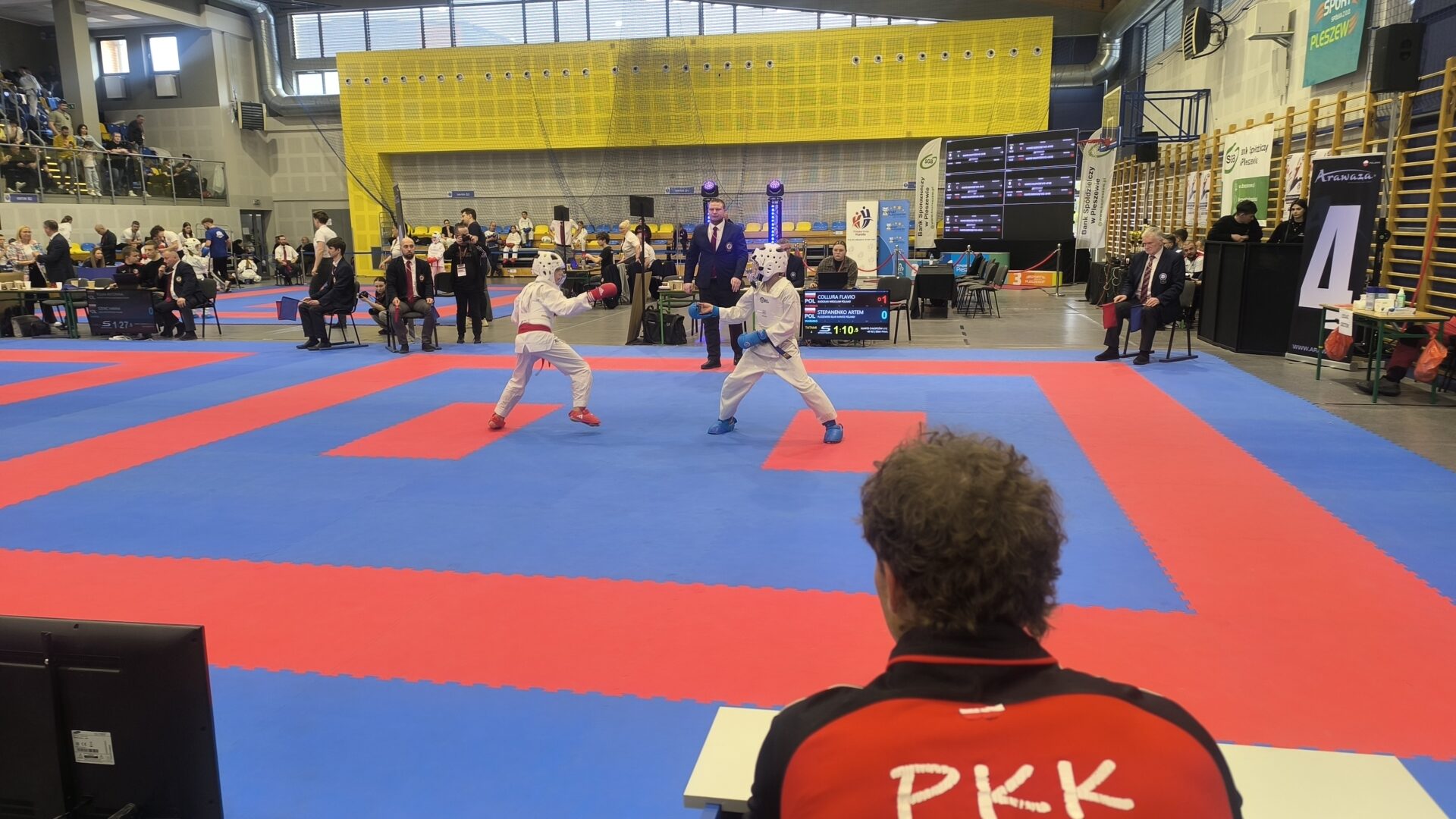 zawodnicy rywalizujący na macie w turnieju karate w hali sportowej w Pleszewie.