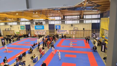 zawodnicy rywalizujący na macie w turnieju karate w hali sportowej w Pleszewie.