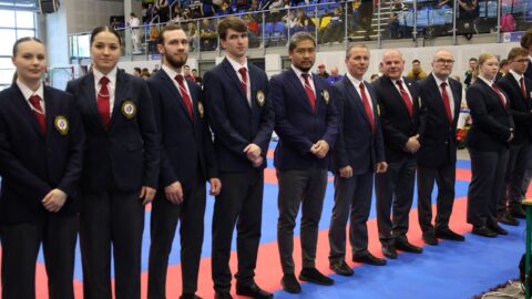 Sędziowie w hali sportowej podczas turnieju karate.
