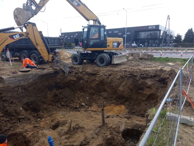 koparka przy wykopanym dole przy centralnej stacji wodociągowej.