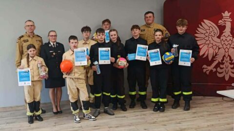 Członkowie Młodzieżowej Drużyny Pożarniczej podczas turnieju pożarniczego OTWP w komendzie straży pożarnej.