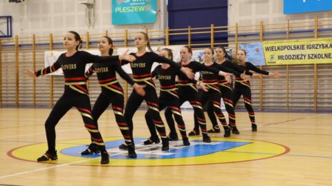 dziewczyny tańczące układ aerobiku w hali sportowej.