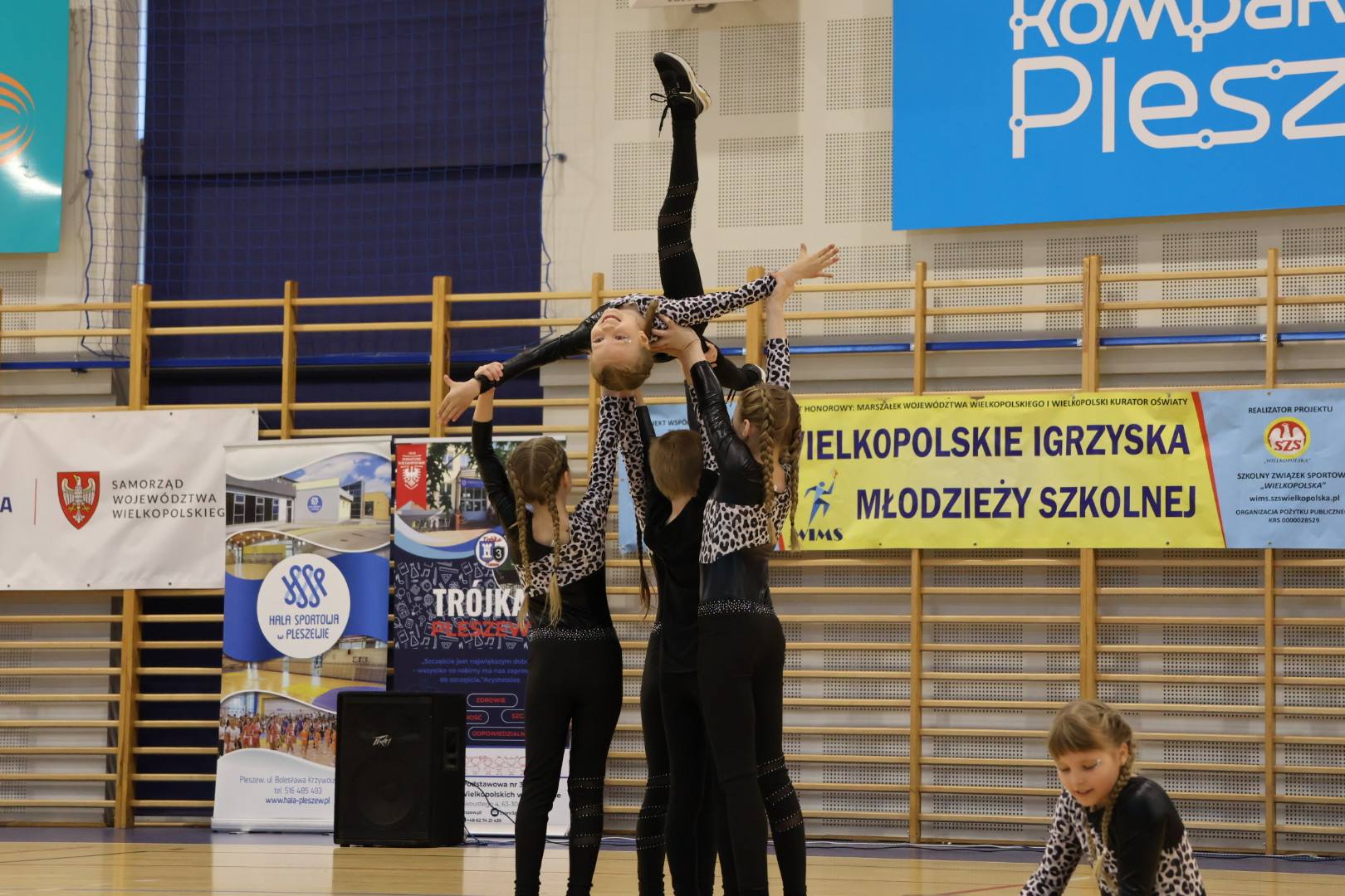 dziewczyny tańczące układ aerobiku w hali sportowej.