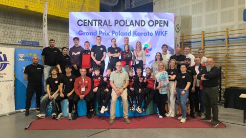 Drużyna na ściance turnieju karate odbywającego się w hali sportowej w Pleszewie.