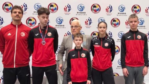 Zawodnicy Pleszewskiego Klubu Karate na ściance turnieju, w którym brali udział w hali sportowej.