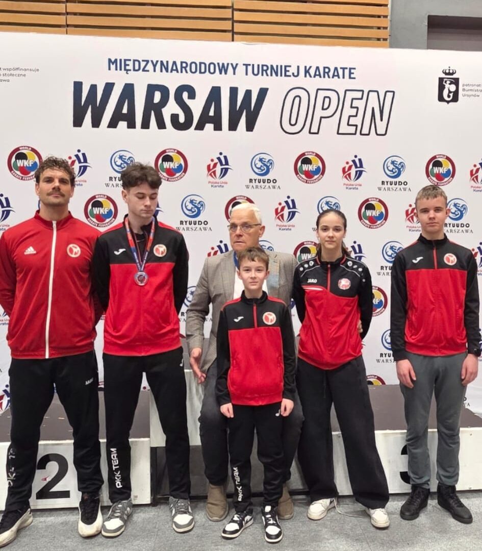 Zawodnicy Pleszewskiego Klubu Karate na ściance turnieju, w którym brali udział w hali sportowej.