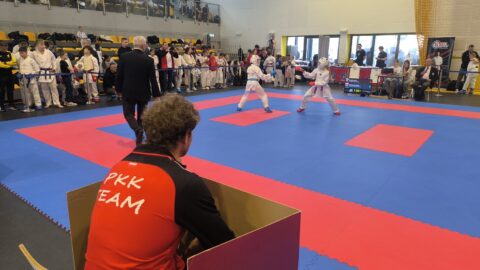 Trener Pleszewskiego Klubu Karate siedzący podczas walki swoich zawodników i obserwujący rywalizację.