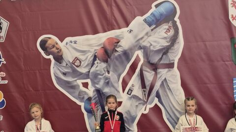 zawodnicy turnieju karate na podium zawodów.