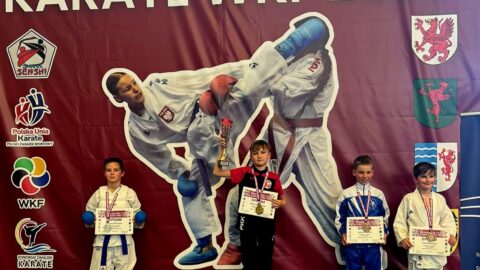 zawodnicy turnieju karate na podium zawodów.