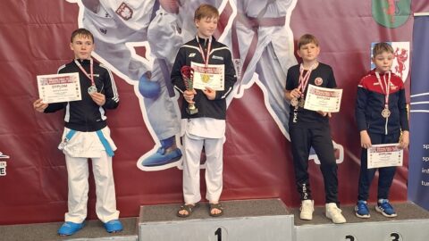 zawodnicy turnieju karate na podium zawodów.