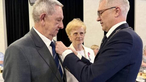 Burmistrz przypinający medale Jubilatom.