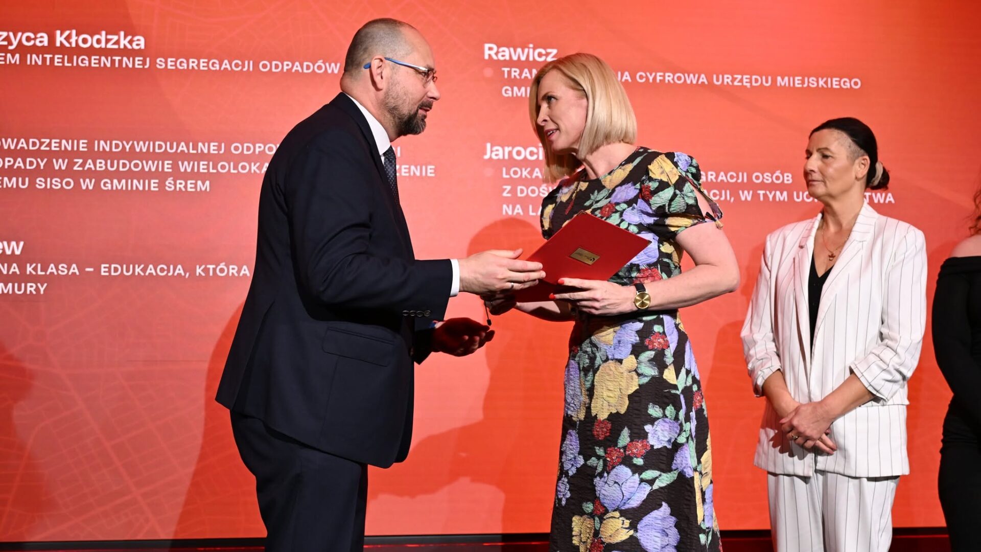 Zastępczyni burmistrza odbierająca statuetkę podczas gali konkursowej na scenie.