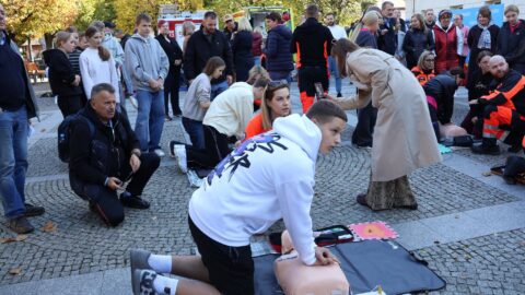 uczniowie ćwiczący na płycie rynku prowadzenie resuscytacji krążeniowej